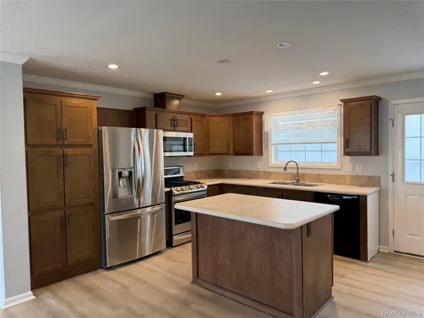 a kitchen with stainless steel appliances granite countertop a refrigerator a sink a stove a microwave and island