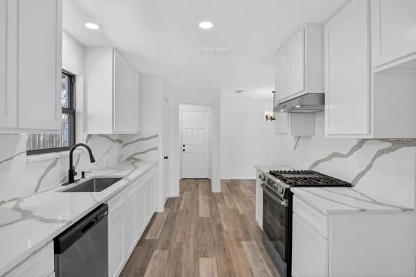 a kitchen with a sink stove top oven and cabinets
