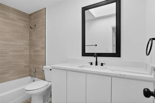 a bathroom with a sink toilet vanity and shower