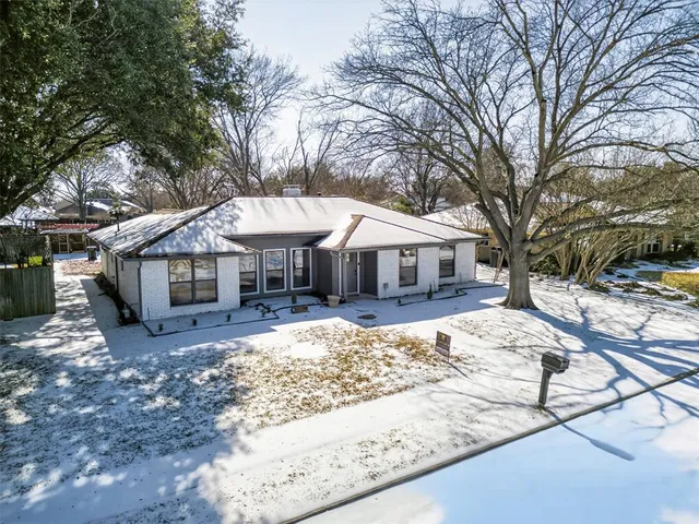 a front view of a house with a yard covered with snow
