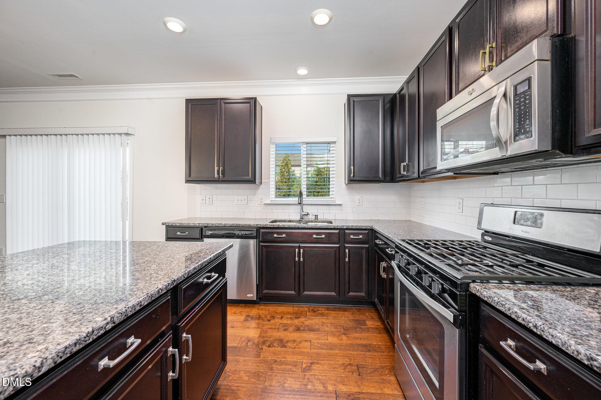 104 Oak Rise Lane Fuquay-Varina, NC 27526 - Photo 8 of 29 a kitchen with stainless steel appliances granite countertop a stove a sink and a microwave