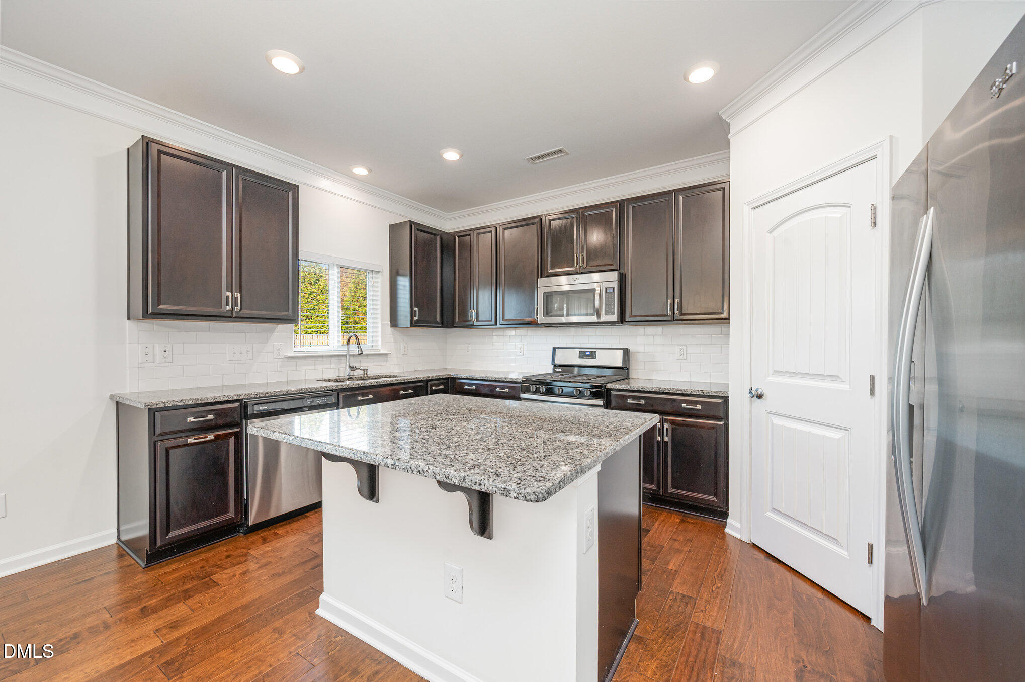 104 Oak Rise Lane Fuquay-Varina, NC 27526 - Photo 7 of 29 a kitchen with stainless steel appliances granite countertop wooden cabinets a refrigerator a stove a sink and a microwave