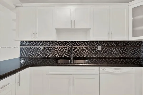 a view of an empty room and chandelier fan