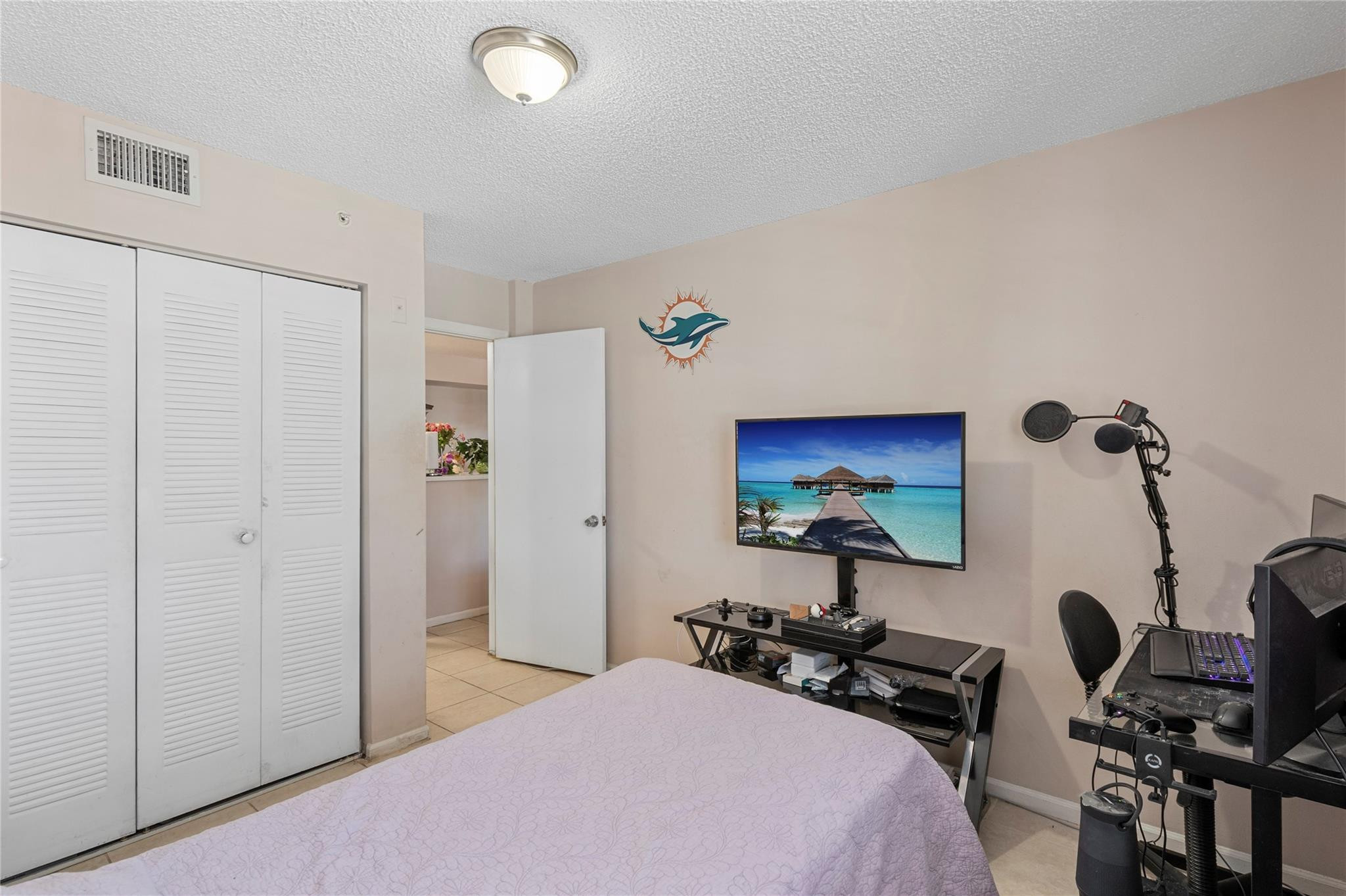 2133 Renaissance Boulevard, Unit 205 Miramar, FL 33025 - Photo 14 of 24 a bedroom with bed and a chandelier
