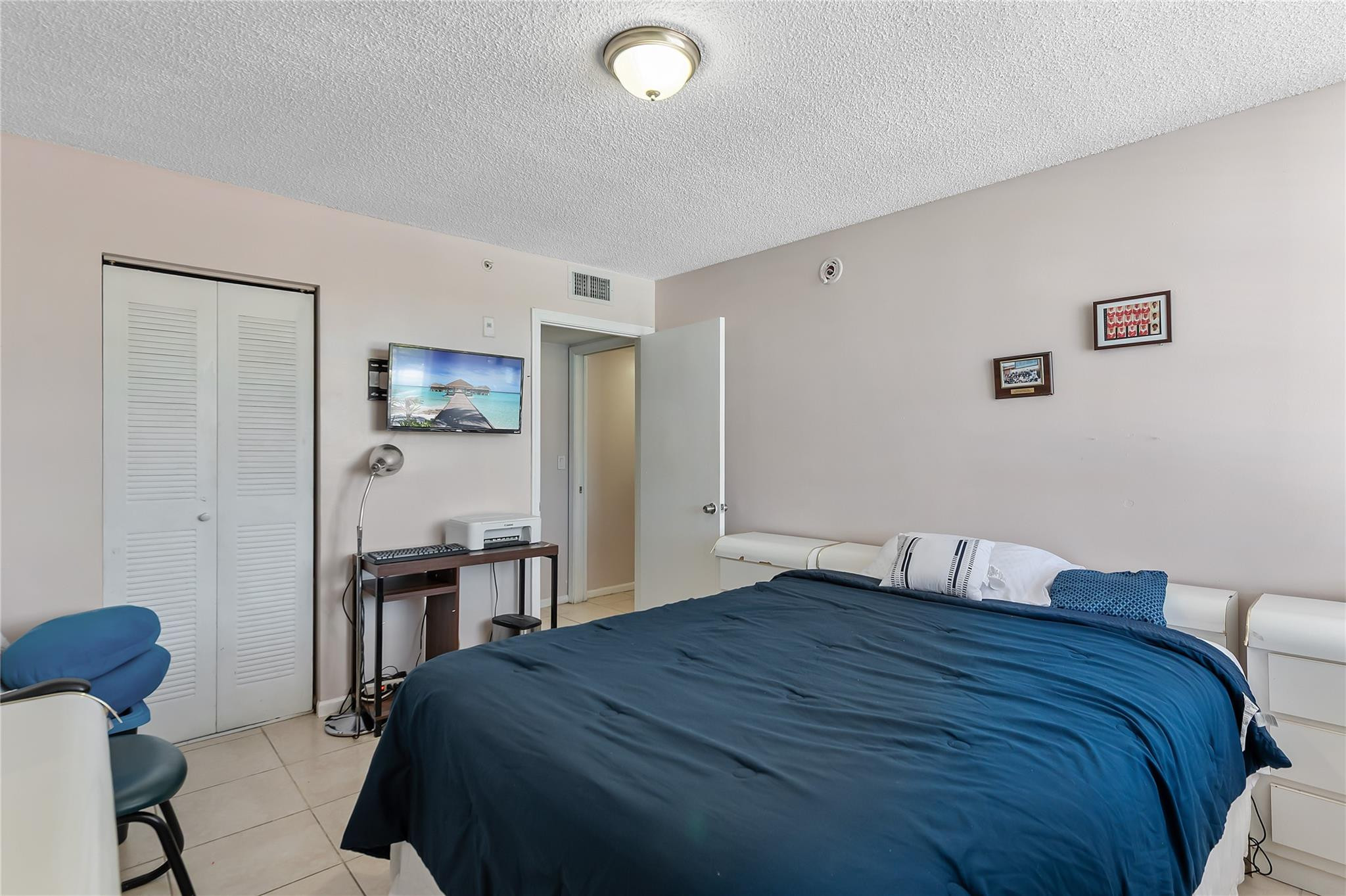2133 Renaissance Boulevard, Unit 205 Miramar, FL 33025 - Photo 16 of 24 a bedroom with a bed and a table in it