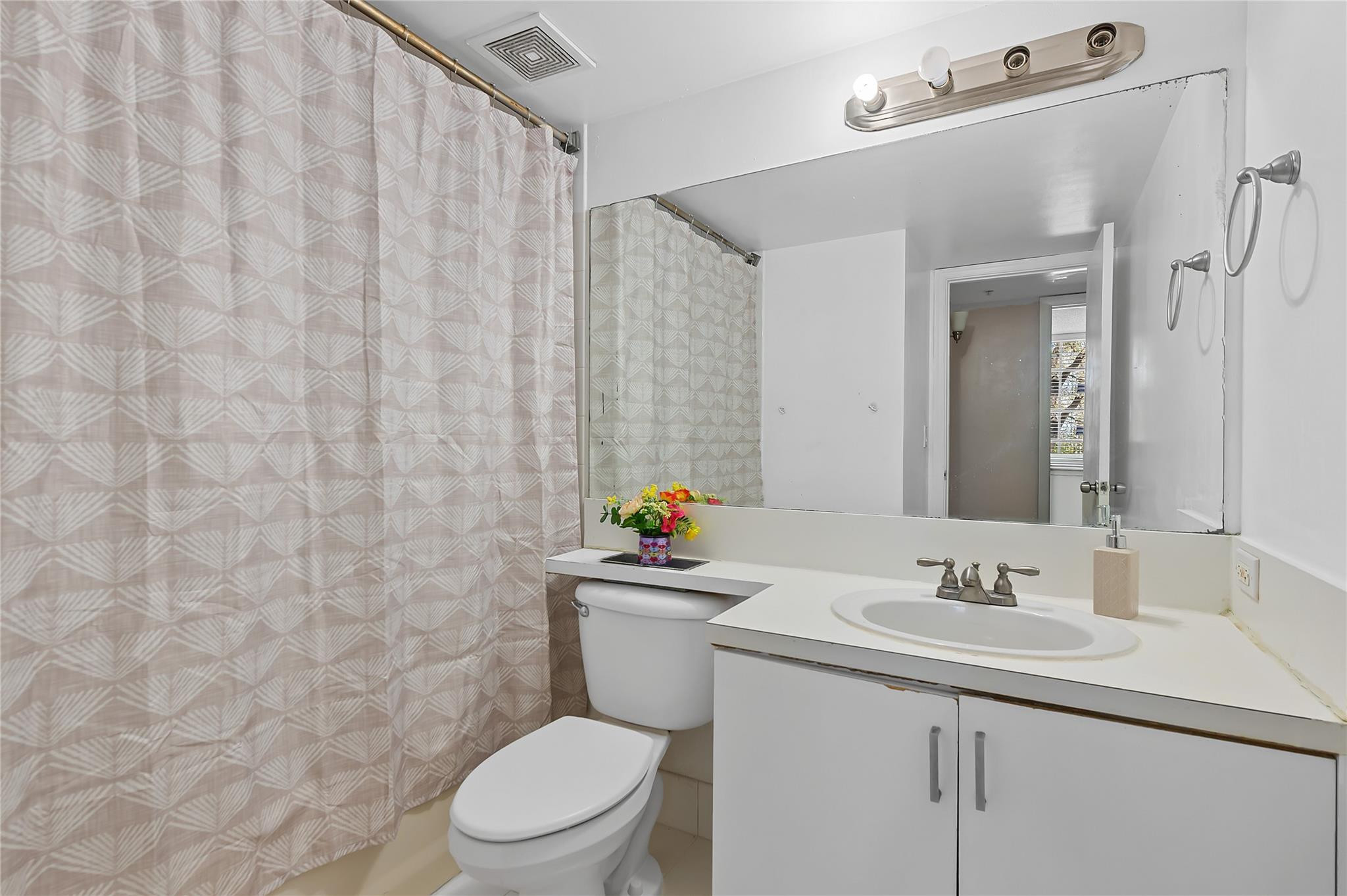 2133 Renaissance Boulevard, Unit 205 Miramar, FL 33025 - Photo 17 of 24 a bathroom with a toilet sink vanity and mirror