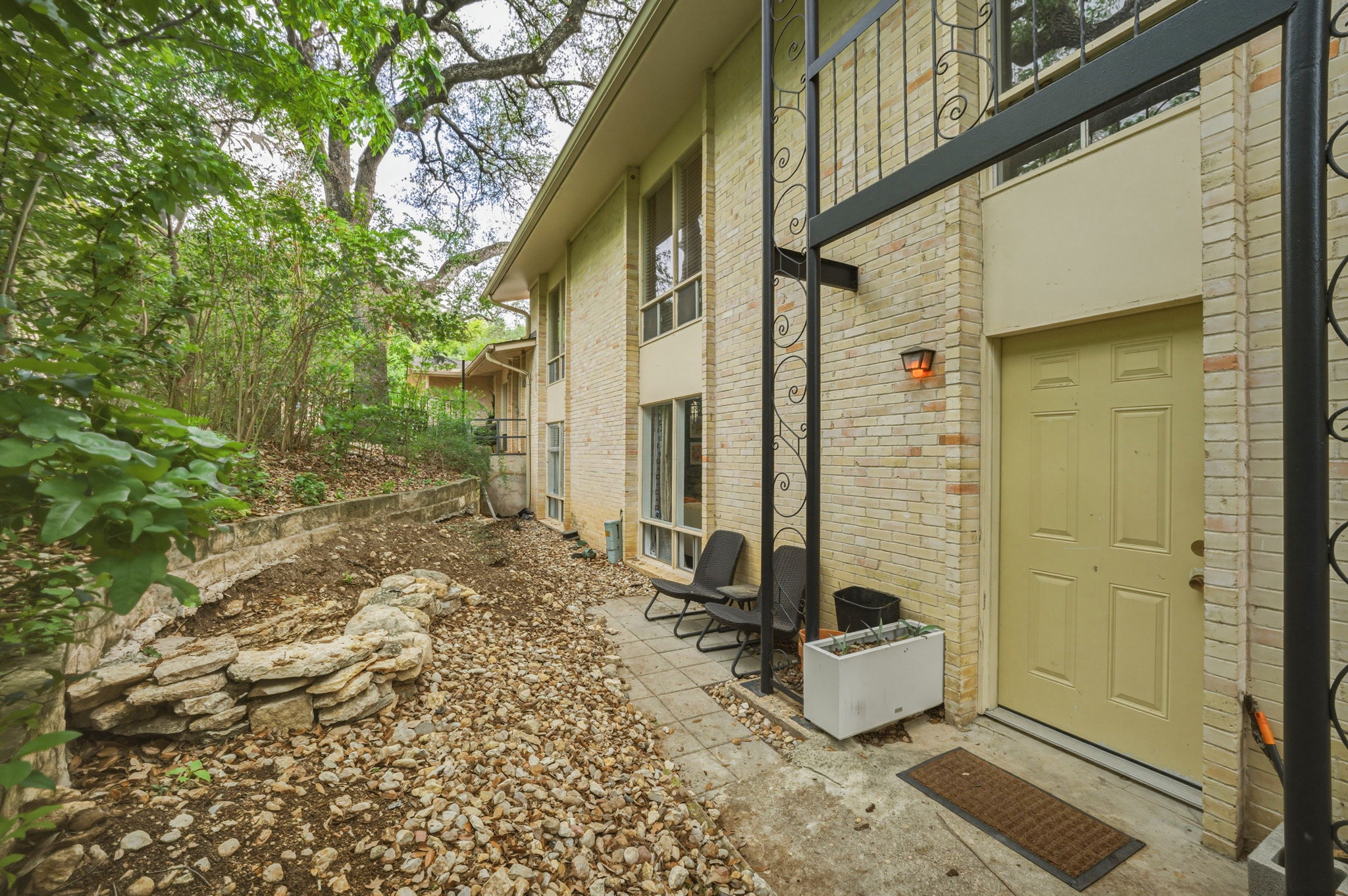 5332 Balcones Drive, Unit B Austin, TX 78731 - Photo 15 of 15 The property features a brick exterior, a light-colored entry door, and a paved walkway leading to the entrance