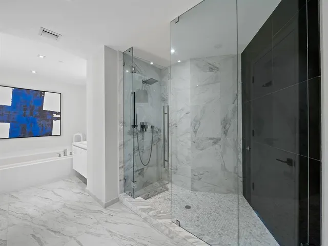 a bathroom with a shower and a bath tub