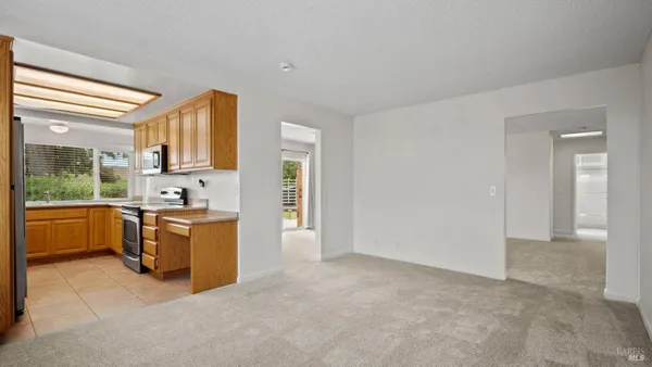 a large kitchen with stainless steel appliances granite countertop a refrigerator and a stove top oven