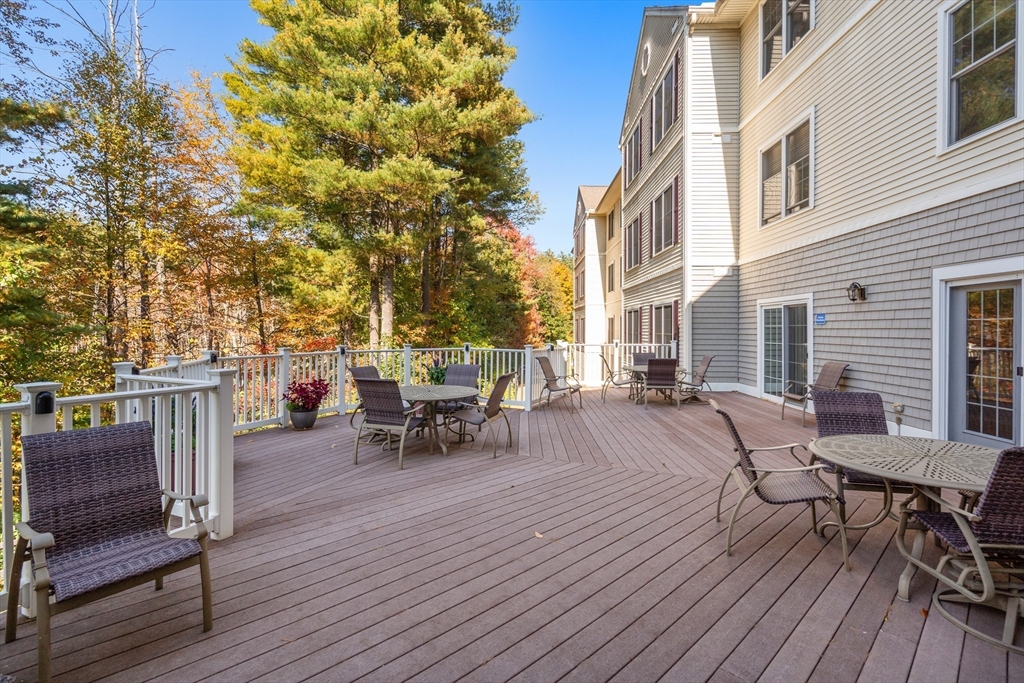 7 Crescent Way, Unit 105 Sturbridge, MA 01518 - Photo 11 of 35 a view of a patio with table and chairs and wooden floor