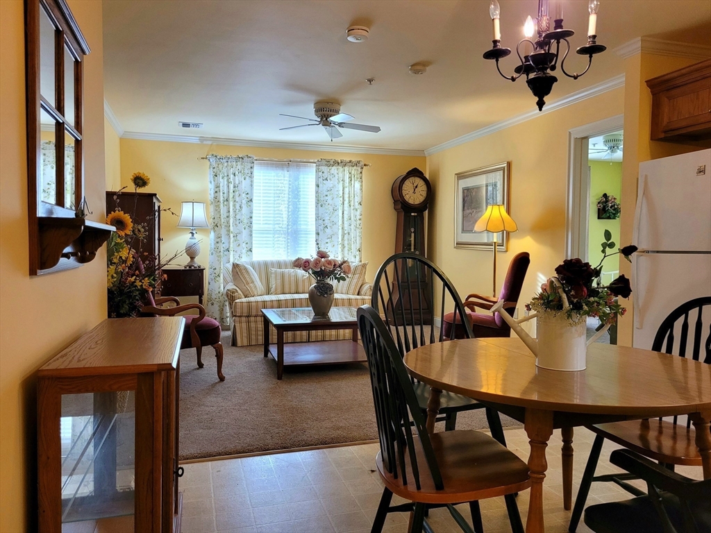 7 Crescent Way, Unit 105 Sturbridge, MA 01518 - Photo 23 of 35 a view of a dining room with furniture and a chandelier