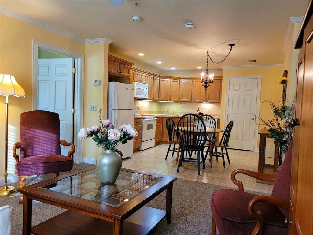 7 Crescent Way, Unit 105 Sturbridge, MA 01518 - Photo 26 of 35 a view of a dining room with furniture and a chandelier