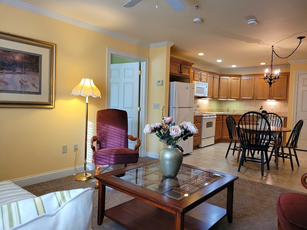 7 Crescent Way, Unit 105 Sturbridge, MA 01518 - Photo 27 of 35 a dining room with furniture and wooden floor