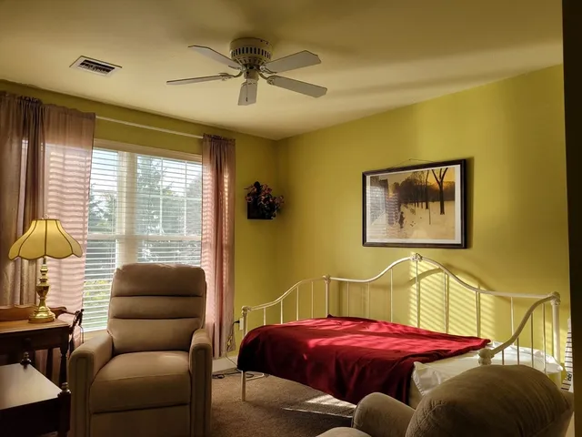 a bedroom with a bed and a chair