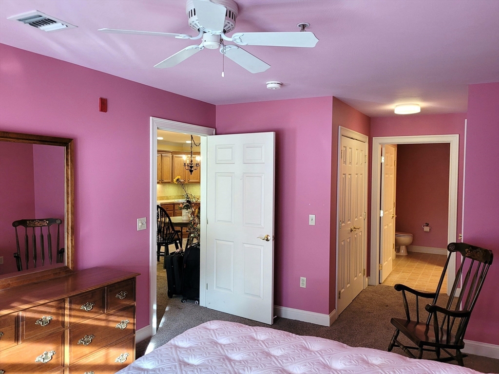 7 Crescent Way, Unit 105 Sturbridge, MA 01518 - Photo 30 of 35 a bedroom with furniture and a chandelier fan
