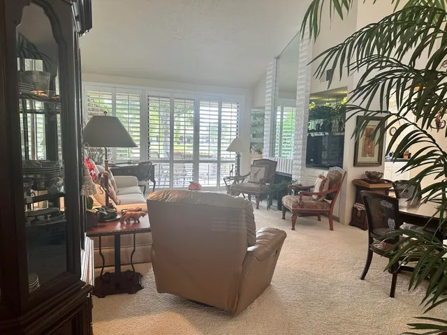 a living room with furniture a chandelier and a dining table