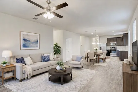 a living room with furniture and a view of kitchen