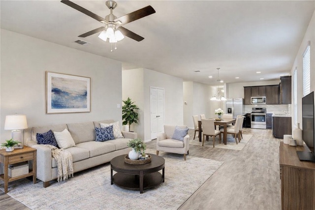 a living room with furniture and a view of kitchen