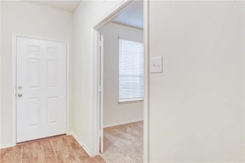 a view of an empty room with wooden floor and closet