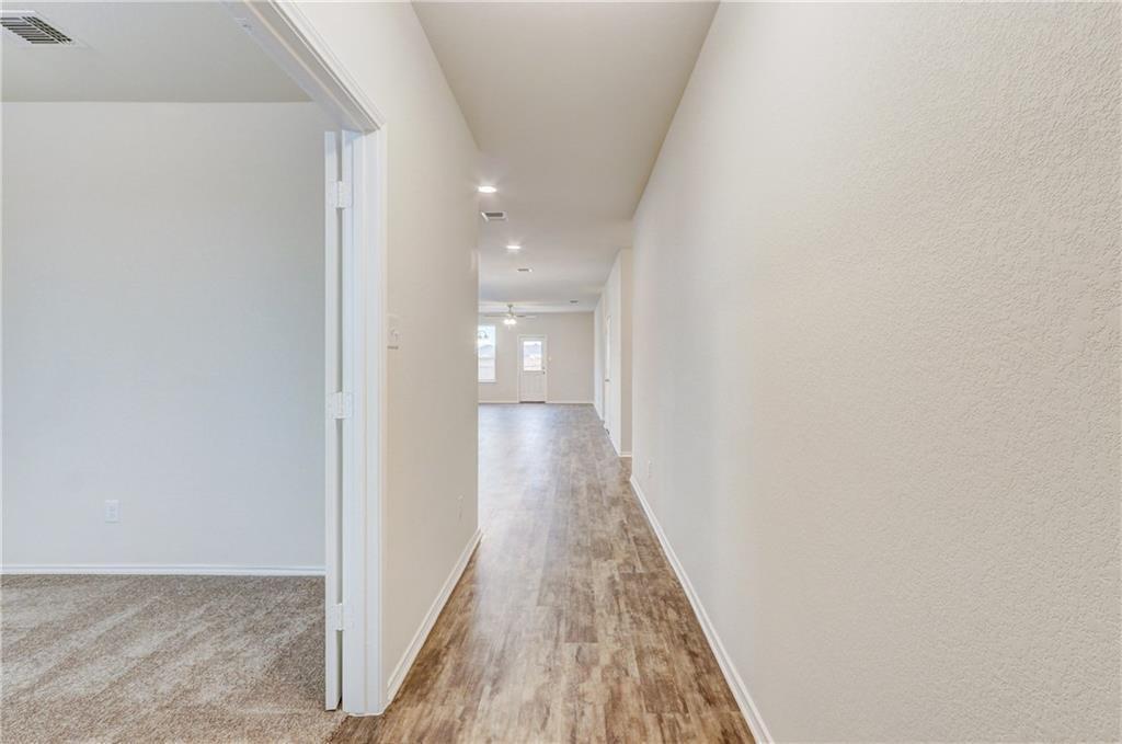 412 Ibis Falls Loop Jarrell, TX 76537 - Photo 6 of 28 a view of a hallway with wooden floor