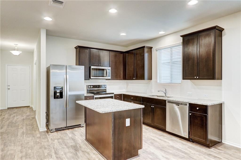 412 Ibis Falls Loop Jarrell, TX 76537 - Photo 8 of 29 kitchen with lots of cabinet space, granite counters & stainless steel appliances - includes refrigerator