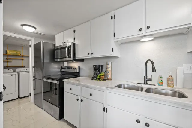 a kitchen with white cabinets and appliances