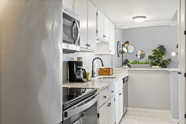 a kitchen with stainless steel appliances a sink a stove and cabinets