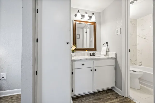 a bathroom with a granite countertop sink toilet and a mirror