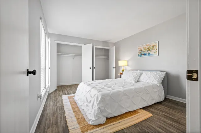 a bedroom with a bed and wooden floor