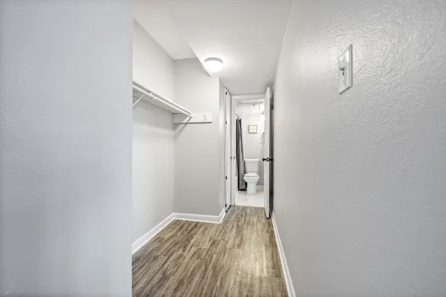 a view of a room with wooden floor and a bathroom