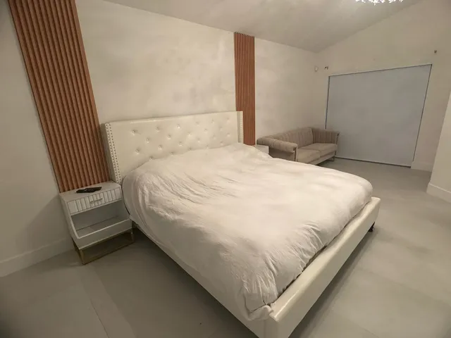 a large bed sitting in a bedroom next to a window