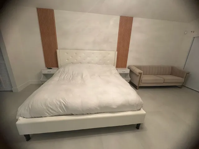 a bed sitting in a room with couch and a rug
