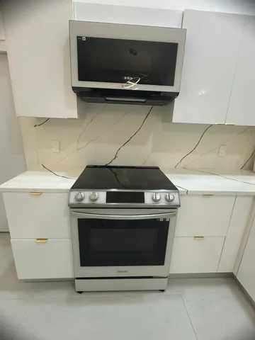 a stove top oven sitting inside of a kitchen