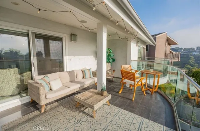 a balcony with wooden floor table and chairs