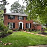a front view of a house with a yard and trees
