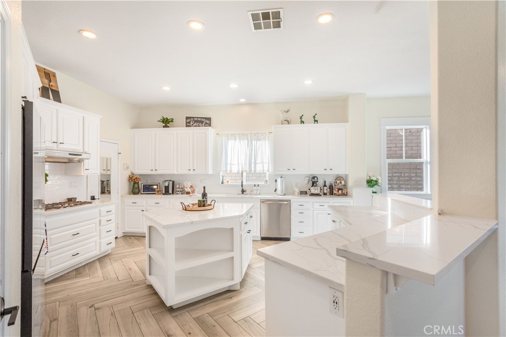 8824 Soothing Court Corona, CA 92883 - Photo 15 of 50 a kitchen with a sink stove and cabinets
