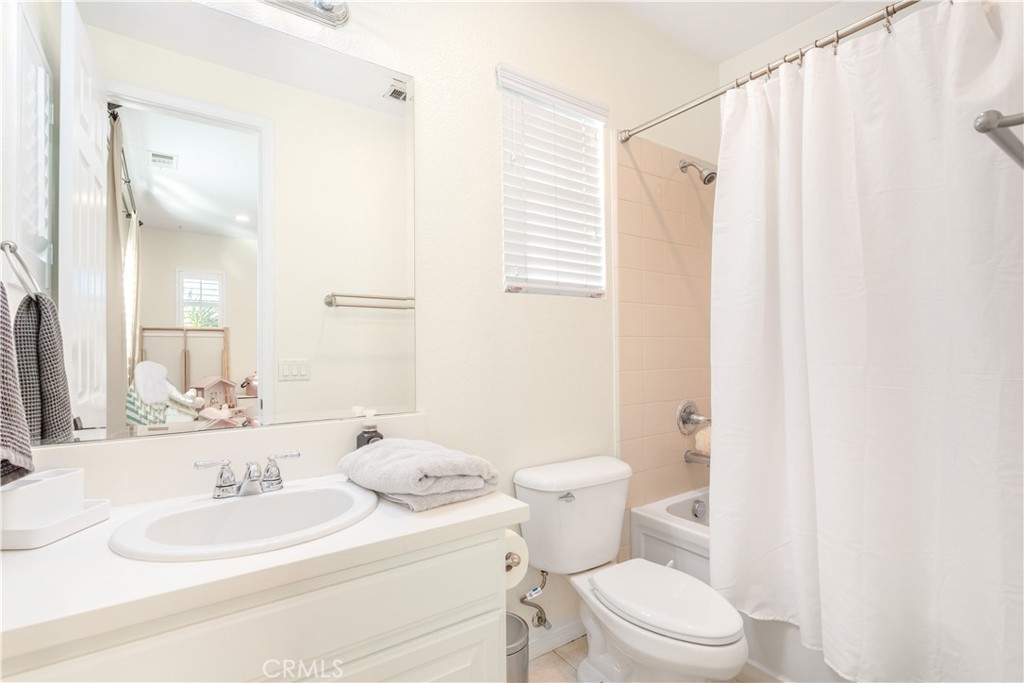 8824 Soothing Court Corona, CA 92883 - Photo 33 of 50 a bathroom with a sink a toilet and shower curtain