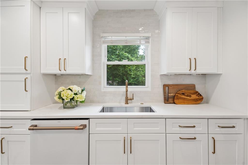 1493 Runnymeade Road Northeast Brookhaven, GA 30319 - Photo 12 of 40 a kitchen with a window a sink and white cabinets