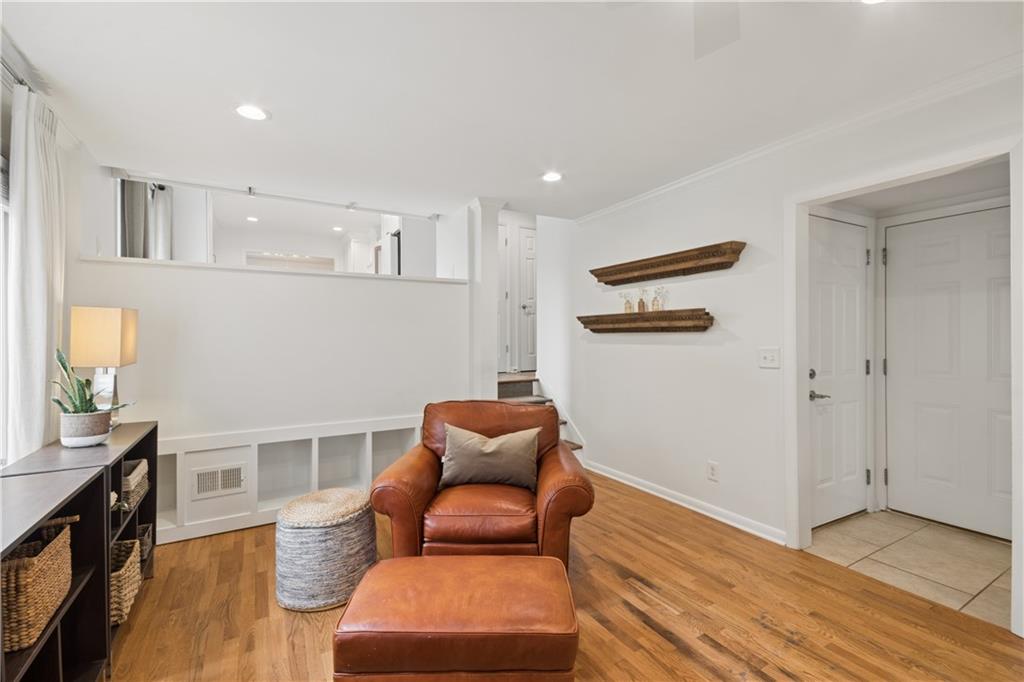 1493 Runnymeade Road Northeast Brookhaven, GA 30319 - Photo 17 of 40 a hallway with a couch and a dining table with wooden floor