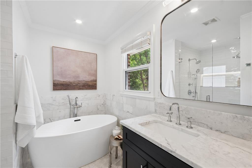 1493 Runnymeade Road Northeast Brookhaven, GA 30319 - Photo 23 of 40 a bathroom with a double vanity sink mirror and a bathtub