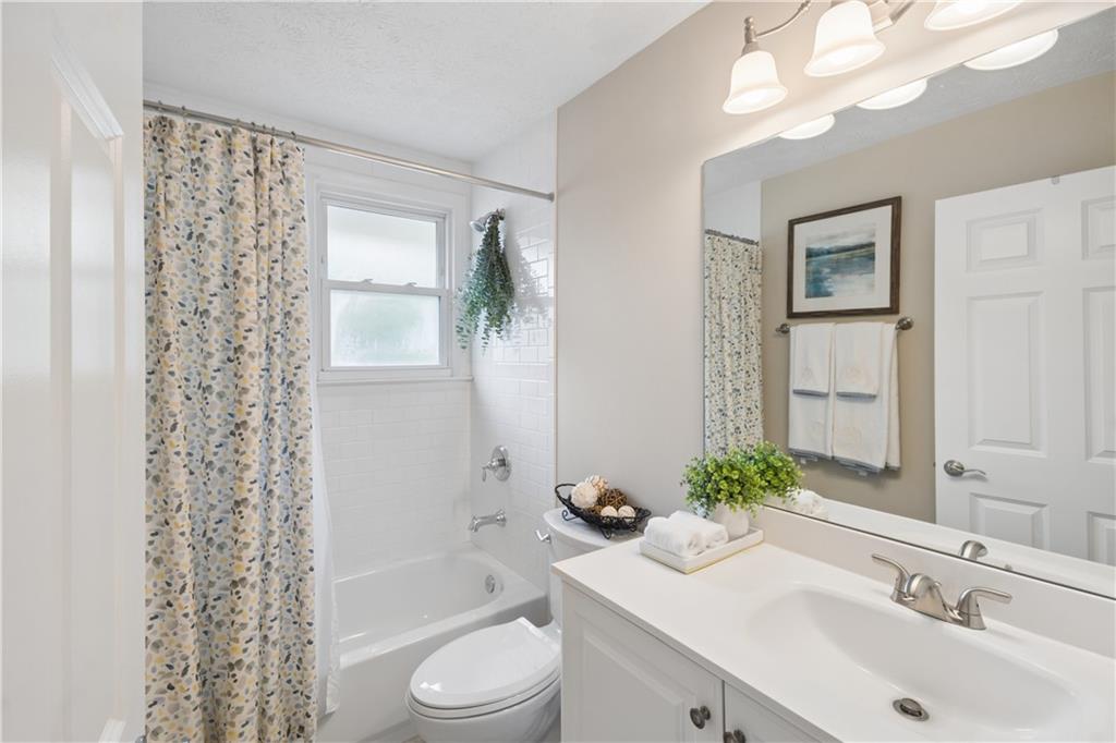 1493 Runnymeade Road Northeast Brookhaven, GA 30319 - Photo 28 of 40 a bathroom with a sink a toilet and shower