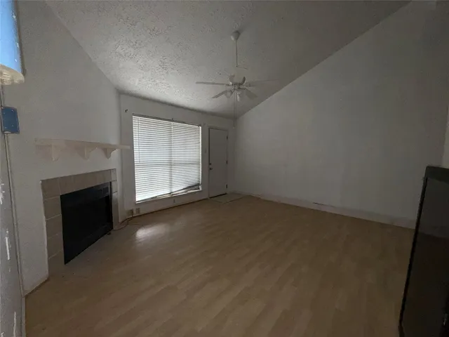 an empty room with windows and fireplace