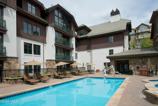a view of a house with swimming pool and sitting area