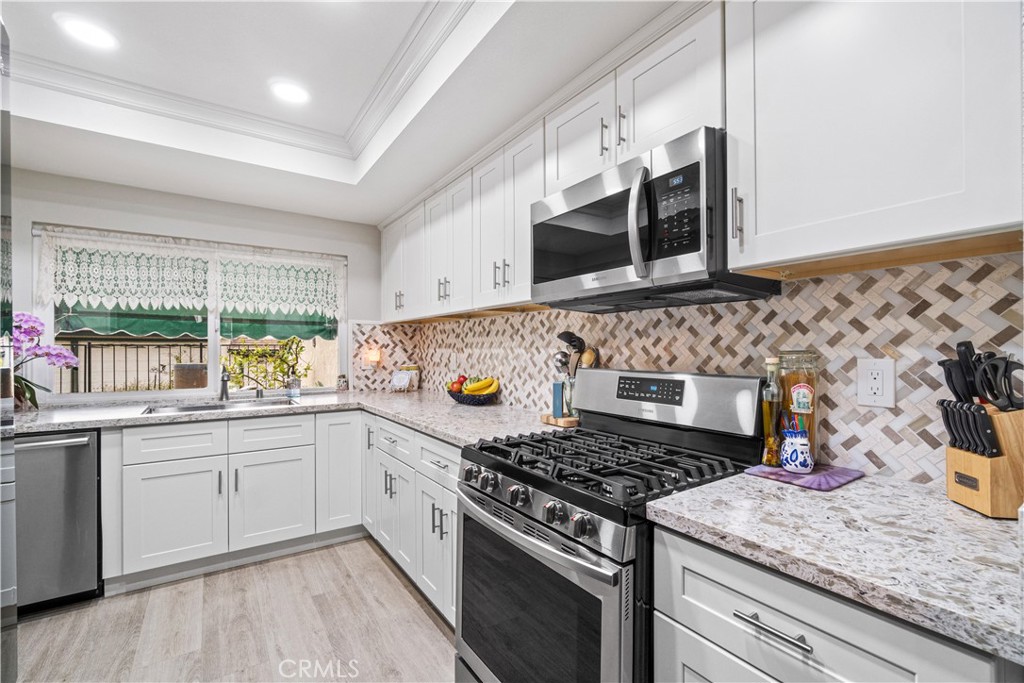 2671 Condor Circle Corona, CA 92882 - Photo 8 of 44 a kitchen with stainless steel appliances granite countertop a stove and a sink