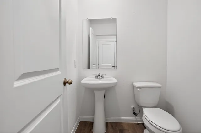 a bathroom with a toilet a sink and mirror