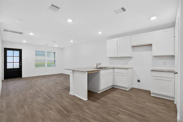 a kitchen with white cabinets and sink
