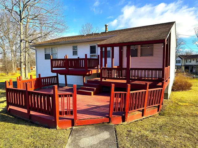a view of a house with wooden deck and furniture