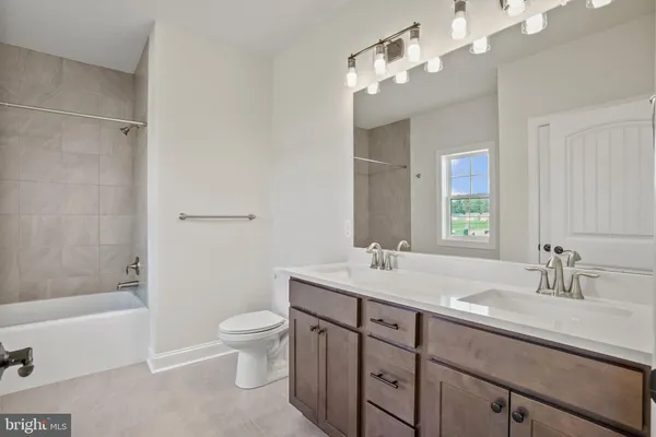 a bathroom with a sink a toilet and a large mirror