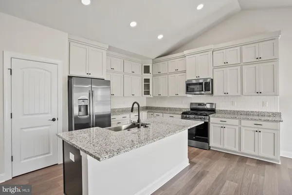 a kitchen with stainless steel appliances granite countertop a stove refrigerator sink and microwave