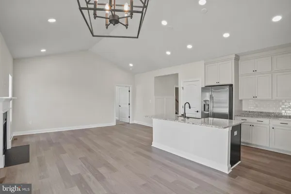 a large white kitchen with a sink and dishwasher a stove with wooden floor